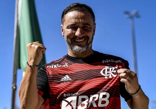 imagem do técnico Vitor Pereira com a camisa do Flamengo enquanto sorri